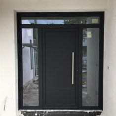 Puerta de entrada con panel ciego y vidrios de seguridad. Tirador de Inox.